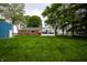 Spacious backyard featuring a well-maintained lawn, mature trees, and a bright sunroom attached to the brick home at 2965 E 1100 N, Pendleton, IN 46064