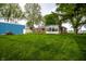 A view of the house from the backyard featuring a shed, a sunroom, and lush green lawn at 2965 E 1100 N, Pendleton, IN 46064