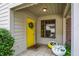 Welcoming entrance with a bright yellow door, fresh flowers, and an inviting welcome mat at 3033 Daum Ct, Carmel, IN 46033