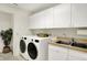 Spacious laundry room offers side-by-side washer and dryer, white cabinets, and utility sink at 3033 Daum Ct, Carmel, IN 46033