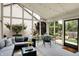 Bright sunroom with large windows, modern furniture, and a view of the landscaped backyard at 3033 Daum Ct, Carmel, IN 46033