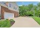 Side view of a brick and siding home featuring an extended driveway leading to a basketball hoop and spacious backyard at 3267 Cimmaron Ash Ct, Zionsville, IN 46077
