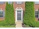 Inviting front entrance framed by symmetrical evergreen shrubs, and decorative trim, offering a welcoming curb appeal at 3267 Cimmaron Ash Ct, Zionsville, IN 46077