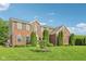 A beautiful brick home with manicured lawn, complimented with mature evergreens, enhancing the property's curb appeal at 3267 Cimmaron Ash Ct, Zionsville, IN 46077