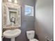 Powder room with pedestal sink, decorative mirror and grey paint at 3267 Cimmaron Ash Ct, Zionsville, IN 46077
