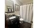 Cozy bathroom featuring a vanity with a black countertop, a framed mirror, and a shower with a striped curtain at 3559 S County Road 475 E, Plainfield, IN 46168