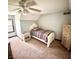 This carpeted bedroom has an off-white ceiling fan, a bed with flower-patterned bedding, and off-white dressers at 3559 S County Road 475 E, Plainfield, IN 46168
