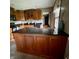 Well-lit kitchen features custom wood cabinetry and large center island with dark granite countertop at 3559 S County Road 475 E, Plainfield, IN 46168