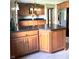 Spacious kitchen features a large island with granite countertop, stainless steel refrigerator and wooden cabinets at 3559 S County Road 475 E, Plainfield, IN 46168