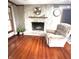Spacious living room with hardwood floors, a stone fireplace, and a comfortable armchair at 3559 S County Road 475 E, Plainfield, IN 46168