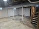 Spacious unfinished basement with concrete flooring, support columns, and staircase at 3644 N Parker Ave, Indianapolis, IN 46218