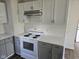 Kitchen showcasing white and gray cabinets, white countertops, and a four-burner stove at 3644 N Parker Ave, Indianapolis, IN 46218