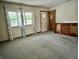 Bright living room with neutral carpet, natural light from large windows, and classic built-in cabinet at 3645 Winings Ave, Indianapolis, IN 46221
