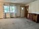Open living room featuring neutral walls, updated carpet and a large window at 3645 Winings Ave, Indianapolis, IN 46221