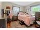Cozy bedroom featuring a plush rug, comfortable bed, and sunny windows with gray curtains at 3702 N Chester Ave, Indianapolis, IN 46218