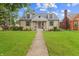 Charming stone house with a well-manicured lawn and inviting front porch and a traditional walkway to the front door at 3702 N Chester Ave, Indianapolis, IN 46218