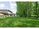Expansive backyard with lush green lawn, mature trees, and a fire pit, perfect for outdoor entertaining and relaxation at 38 Hawthorne Ct, Carmel, IN 46033