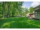 Lush backyard with a well-maintained lawn, mature trees, and a charming deck, ideal for outdoor activities and relaxation at 38 Hawthorne Ct, Carmel, IN 46033