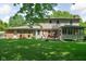 Expansive backyard with a lush lawn, mature trees, and a charming deck, perfect for outdoor gatherings and relaxation at 38 Hawthorne Ct, Carmel, IN 46033
