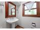 Classic bathroom with pedestal sink, dark-stained mirror frame and a window at 38 Hawthorne Ct, Carmel, IN 46033