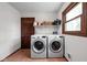 Well-lit laundry room with a front-load washer, dryer, utility sink, and plenty of storage space at 38 Hawthorne Ct, Carmel, IN 46033