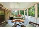 Cozy sunroom with brick accent wall, large windows, and comfortable seating, perfect for relaxing and enjoying the view at 38 Hawthorne Ct, Carmel, IN 46033