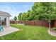 Spacious green backyard featuring a wood fence, garden bed, and back patio at 4256 Zachary Ln, Westfield, IN 46062