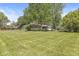 Spacious front yard featuring a charming single-story home with an attached garage and mature trees at 4622 S Franklin Rd, Indianapolis, IN 46239