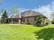 Spacious backyard with lush green lawn, mature trees, and brick patio provides ample space at 5200 W Shoreline Ter, Muncie, IN 47304