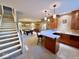 Finished basement with stairs, wet bar, pool table, and seating area at 5200 W Shoreline Ter, Muncie, IN 47304