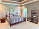 A spacious bedroom featuring tray ceilings, neutral walls, and a comfortable bed with striped bedding at 5200 W Shoreline Ter, Muncie, IN 47304