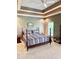 A spacious bedroom featuring tray ceilings, neutral walls, and a comfortable bed with striped bedding at 5200 W Shoreline Ter, Muncie, IN 47304