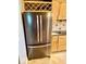 Stainless steel refrigerator with a wine rack above it, nestled between the wood cabinets at 5200 W Shoreline Ter, Muncie, IN 47304