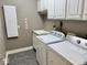 Laundry room with white cabinets, a utility sink, and modern appliances at 5200 W Shoreline Ter, Muncie, IN 47304