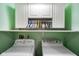 Laundry room features laundry machines and hanging cabinets with green walls at 5361 Cradle River Ct, Indianapolis, IN 46221