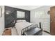 Comfortable bedroom featuring a stylish accent wall and soft, natural light from two windows at 5427 Heights Ave, Indianapolis, IN 46237