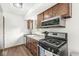 Kitchen with stainless steel appliances and wooden cabinetry with a gas range at 5427 Heights Ave, Indianapolis, IN 46237