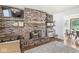 Cozy living room with a red brick fireplace, wooden mantle, and open shelving at 5427 Heights Ave, Indianapolis, IN 46237