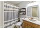 Clean bathroom featuring a shower with gray and white striped curtain and wood vanity at 560 Old Farm Rd, Danville, IN 46122