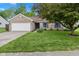 Charming brick home featuring a well-manicured lawn, mature trees, and an attached two-car garage at 560 Old Farm Rd, Danville, IN 46122