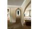 Hallway with arched doorways leading to a bright living room and kitchen, offering a glimpse of the home's layout at 5960 Southeastern Ave, Indianapolis, IN 46203