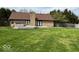 Spacious backyard featuring a brick house with a deck and a hot tub, perfect for outdoor living at 6143 Roberts Pl, Indianapolis, IN 46220