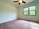 Neutral bedroom features carpet, a ceiling fan and a large window to view the outdoors at 6143 Roberts Pl, Indianapolis, IN 46220