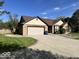 Well-kept home with an attached two-car garage, tidy landscaping, and a spacious driveway at 6143 Roberts Pl, Indianapolis, IN 46220