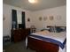 Comfortable bedroom featuring a classic wood bed frame, dresser, and stylish decor at 6723 S New Jersey St, Indianapolis, IN 46227