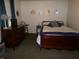 Comfortable bedroom featuring a classic wood bed frame, dresser, and stylish decor at 6723 S New Jersey St, Indianapolis, IN 46227