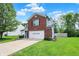 Two-story home with brick facade, white garage door, and long driveway at 6809 Amber Springs Way, Indianapolis, IN 46237