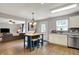 Kitchen with tile backsplash, white cabinets, stainless appliances and an island open to the living room at 6809 Amber Springs Way, Indianapolis, IN 46237