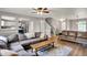 Inviting living room featuring hardwood floors, comfortable sofas, and an open layout to the kitchen at 6809 Amber Springs Way, Indianapolis, IN 46237