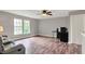 Bright living room featuring laminate floors, two windows offering natural light, and a ceiling fan at 6809 Amber Springs Way, Indianapolis, IN 46237